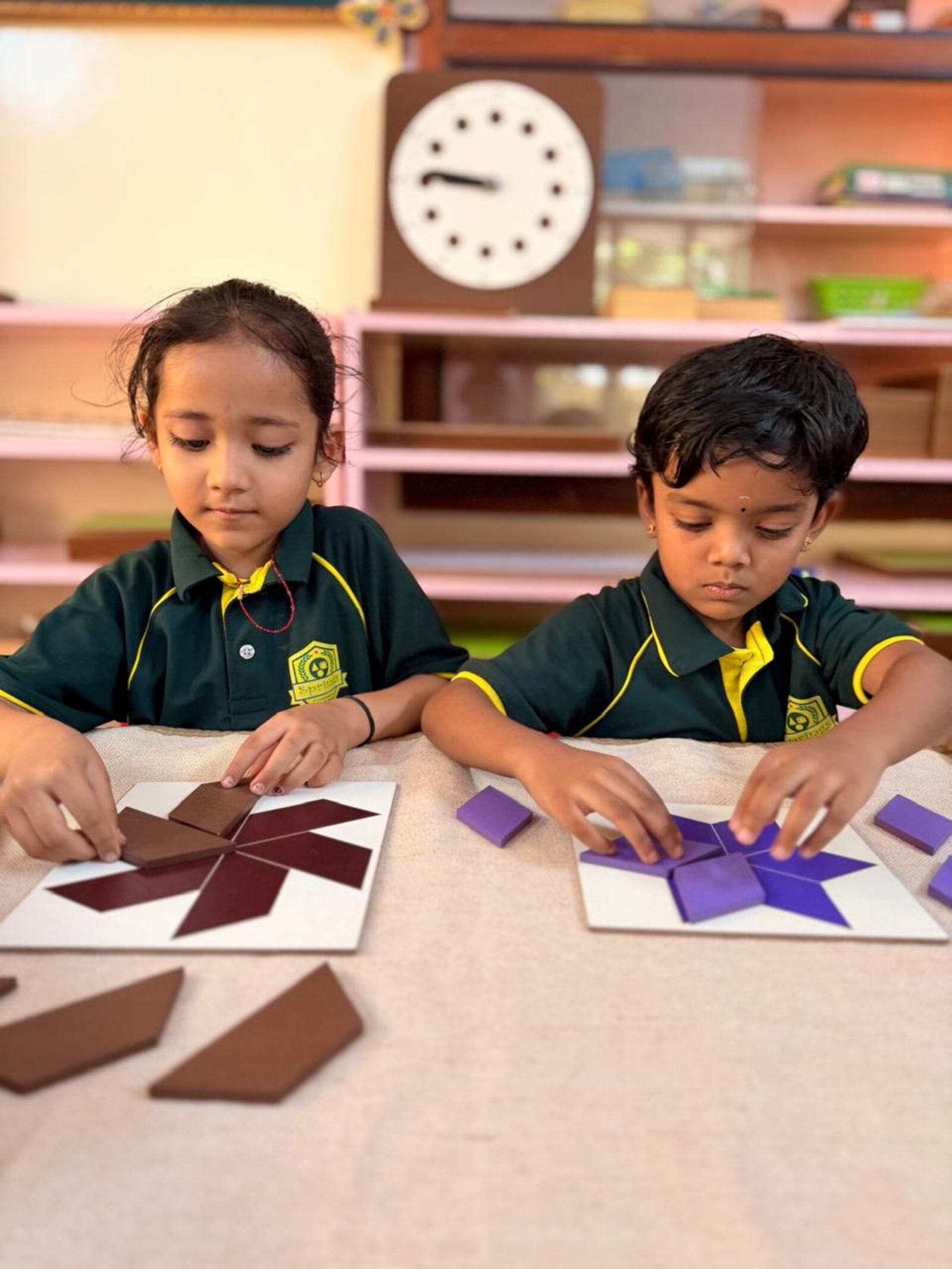 Two children working with Montessori geometric puzzle materials